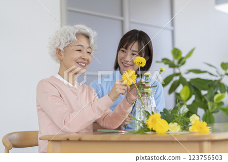 Senior woman and care staff enjoying flower arranging 123756503
