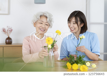 老年婦女和照護人員正在享受插花 123756643