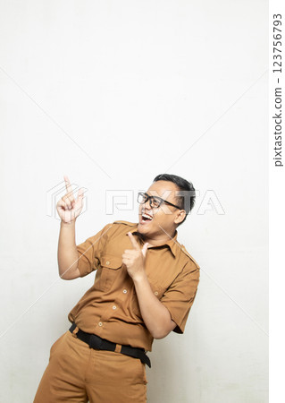 Profile of Indonesian school teacher wearing khaki uniform. Excited Indonesian government worker pointing left into empty space. 123756793
