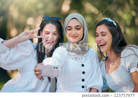 Selfie, phone and friends in nature park relax, bond or enjoy outdoor quality time together on spring day. Smile, goofy or fun group of people, girl or diversity women post to online social media app Selfie, phone and friends in nature park relax, bond or enjoy outdoor quality time together on spring day. Smile, goofy or fun group of people, girl or diversity women post to online social media app 123757977
