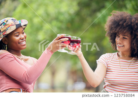 Toast, celebration and friends with wine on a picnic in a park together during summer. Happy, relax and African women with cheers and glasses of alcohol to celebrate birthday in nature garden 123758084