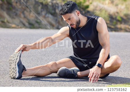 Fitness, exercise and stretching with a sports man preparing for a workout or cardio training on a road in nature. Health, wellness and performance with a male athlete at the start of a routine Fitness, exercise and stretching with a sports man preparing for a workout or cardio training on a road in nature. Health, wellness and performance with a male athlete at the start of a routine 123758162