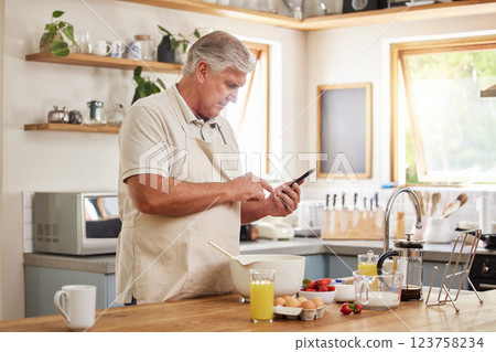 Senior man on a phone for cooking recipe, making breakfast in kitchen at home. Retirement, hobby and chef skill for old man on internet on smartphone online for ideas for healthy meal in the morning Senior man on a phone for cooking recipe, making breakfast in kitchen at home. Retirement, hobby and chef skill for old man on internet on smartphone online for ideas for healthy meal in the morning 123758234