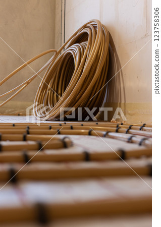 Hank of pipes for underfloor water heating system. Closeup, selective focus. Hank of pipes for underfloor water heating system. Closeup, selective focus. 123758306
