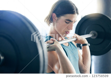 Fitness, gym and man doing barbell shoulder press exercise for strong or powerful arm muscles and bodybuilding. Bodybuilder strength training and weightlifting workout with discipline and effort 123758509