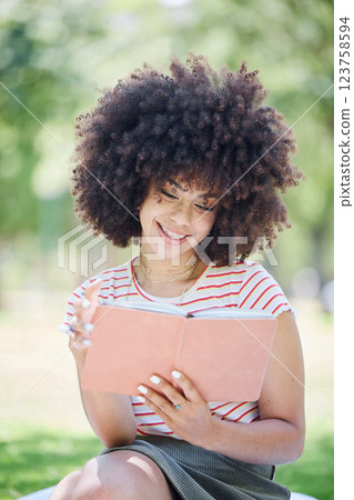 Book, education and park with a woman student reading on a university or college campus. Study, learning and scholarship with a young female pupil studying from a textbook on a field of grass 123758594