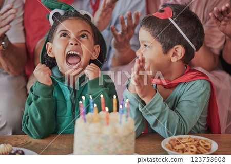 Happy birthday, party and children in halloween costume to celebrate young and fun girls special day together. Cake, fantasy and excited kid in a dinosaur monster outfit and boy in a superheroes cape 123758608