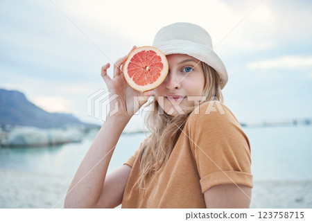 Grapefruit, wellness and woman on tropical beach for nature holiday, vacation or outdoor vitamin c health. Vegan, youth lifestyle for skin care, detox or healthy eating with sky mockup and sea water 123758715