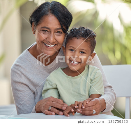 Senior grandma with young boy, smile in portrait together at table in garden at her house. Grandmother in retirement, happy to spend time with male grandchild outdoors at family home or on vacation 123759353