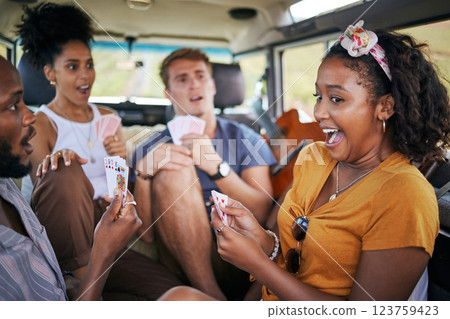 Playing cards, road trip and friends in van winning and excited for adventure journey, holiday and youth games lifestyle. Diversity group of people, camping and winner with card game in a caravan car 123759423