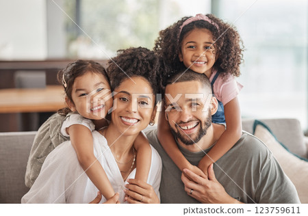 Happy, smile and portrait of an interracial family sitting on a sofa in the living room at home. Happiness, love and adoptive parents bonding, embracing and relaxing with their children in the lounge 123759611