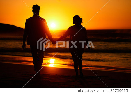 Ocean sunset, couple walking and beach water at night or woman and man love holding hands at sea summer vacation. Travel together, honeymoon silhouette and bonding on holiday sky sunlight in nature 123759615
