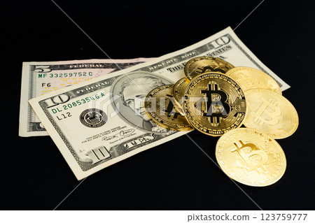 Bitcoin cryptocurrency with US dollar banknote on black background. Bitcoin cryptocurrency with US dollar banknote on black background. 123759777