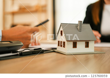 Businesswoman embraces client after successful property negotiation. 123760059