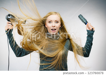 Girl holds hair accessories, styling hair 123760878