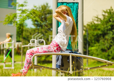 Girl doing situps in outdoor gym 123760908