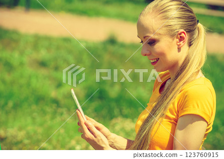 Girl outdoor, holding phone 123760915