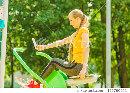 Girl doing exercises outdoor, taking selfie 123760921