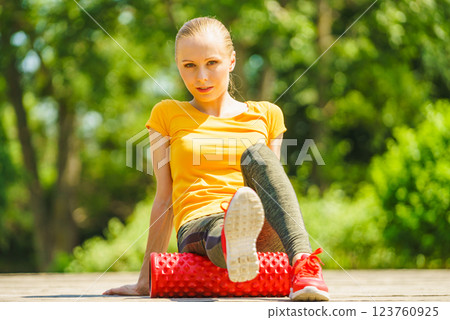 Girl doing exercises outdoor, using roller 123760925