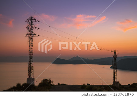 High voltage towers on coast at sunset High voltage towers on coast at sunset 123761970