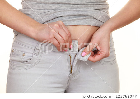 Woman with belly fat unable to close the pants 123762077