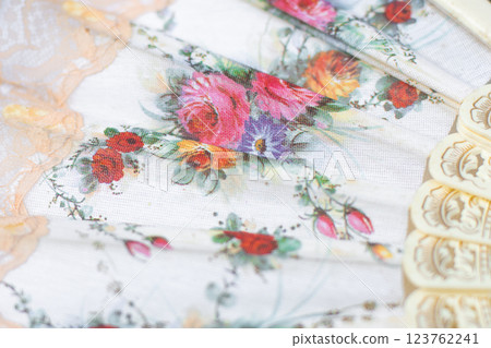 Open white fan with flowers at the flea market in France 123762241