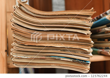 Stack of worn tattered antique newspapers or magazine in a vintage shop 123762244