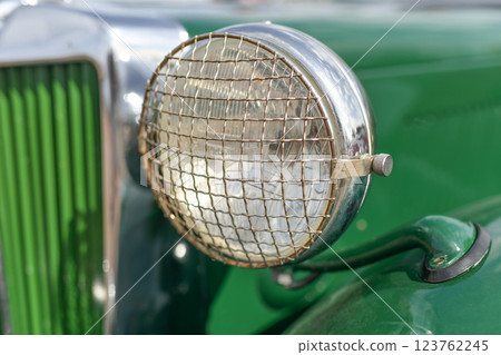 Close up green vintage car chrome rusty rearview side mirror 123762245