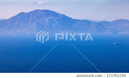 View from Gibraltar, British Overseas Territory on the Iberian Peninsula. Distant mountain range viewed across a calm expanse of ocean, with a few ships visible on the horizon. 123762294