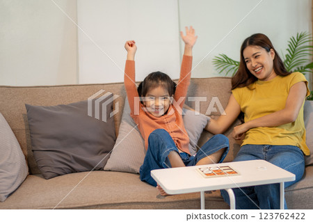Lovely mom and little young daughter spending time together in their living room. 123762422