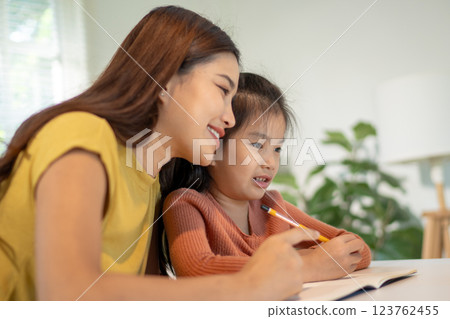 Lovely mom and little young daughter spending time together in their living room. Lovely mom and little young daughter spending time together in their living room. 123762455