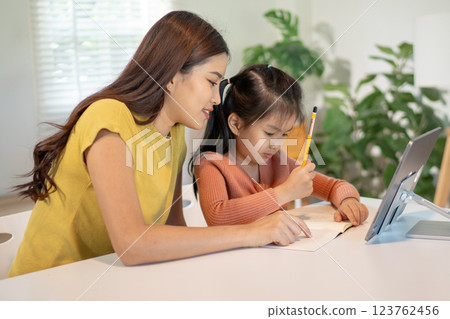 Lovely mom and little young daughter spending time together in their living room. Lovely mom and little young daughter spending time together in their living room. 123762456