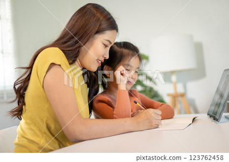 Lovely mom and little young daughter spending time together in their living room. Lovely mom and little young daughter spending time together in their living room. 123762458