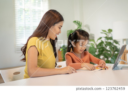 Lovely mom and little young daughter spending time together in their living room. Lovely mom and little young daughter spending time together in their living room. 123762459