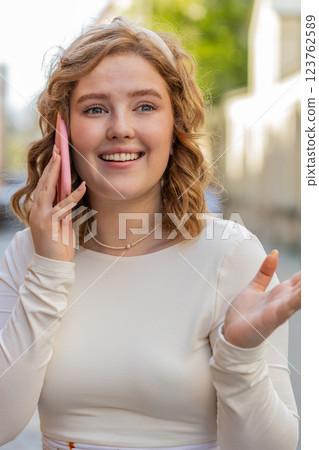 Happy surprised woman involved in pleasant conversation phone call good news enjoying talking gossip Happy surprised woman involved in pleasant conversation phone call good news enjoying talking gossip 123762589