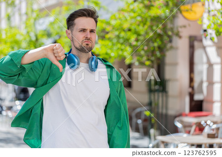 Man showing thumbs down sign dislike expressing discontent disapproval dissatisfied bad work mistake 123762595