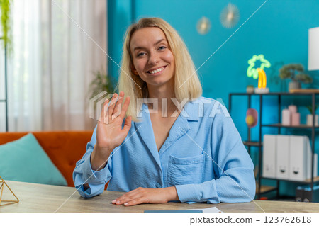 Businesswoman smiling friendly at camera and waving hands gesturing hello, hi, greeting or goodbye Businesswoman smiling friendly at camera and waving hands gesturing hello, hi, greeting or goodbye 123762618