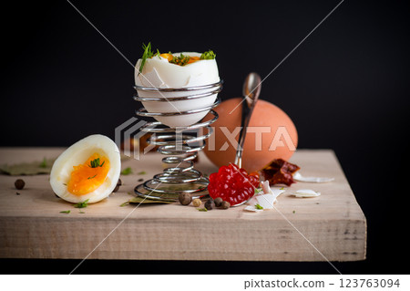 red caviar in a spoon and morning boiled egg for breakfast, isolated on black background 123763094