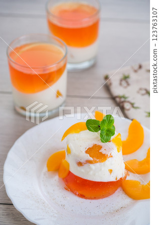 Layered fruit dessert with jelly, cream and fresh mint on a wooden table 123763107
