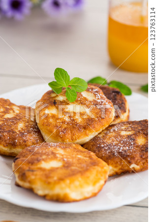 Appetizing cheese pancakes with a golden crust and a drop of honey 123763114