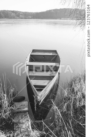 A small fishing boat on the shore of a lake, Barlinek, Poland. A small fishing boat on the shore of a lake, Barlinek, Poland. 123763164