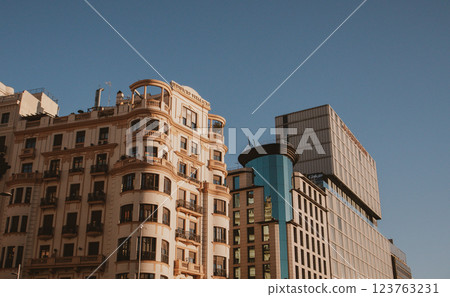 Skyscraper view from bottom to top against dark blue sunset sky. Tall multi-story residential or business building in urban city environment Cityscape 123763231