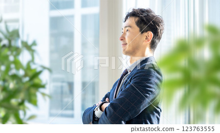 Smiling male businessman with arms crossed 123763555