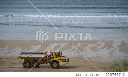 Heavy machinery transports sand along the biscarosse dune coastline, addressing coastal erosion 123763742