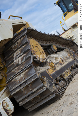 Construction equipment working along the coastline to manage erosion and prevent environmental 123763747