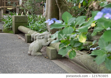 A stone statue decorated with hydrangeas and stone figures A stone statue decorated with hydrangeas and stone figures 123763805