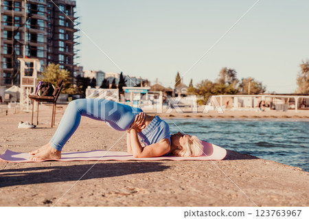 Yoga Beach Pose Woman - Practicing yoga on a beach by the sea at sunset. 123763967