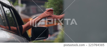 Hand Man in car receiving coffee in drive thru fast food restaurant. 123764385