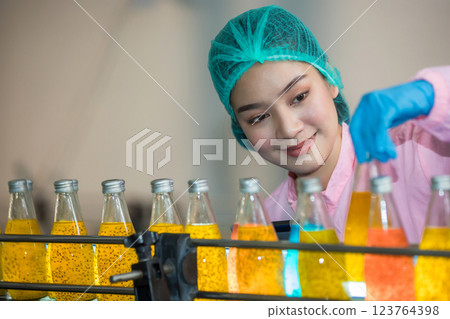 Worker Checking quality or checking stock of glass bottle in beverage factory Worker Checking quality or checking stock of glass bottle in beverage factory 123764398