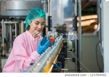 Worker Checking quality or checking stock of glass bottle in beverage factory 123764402